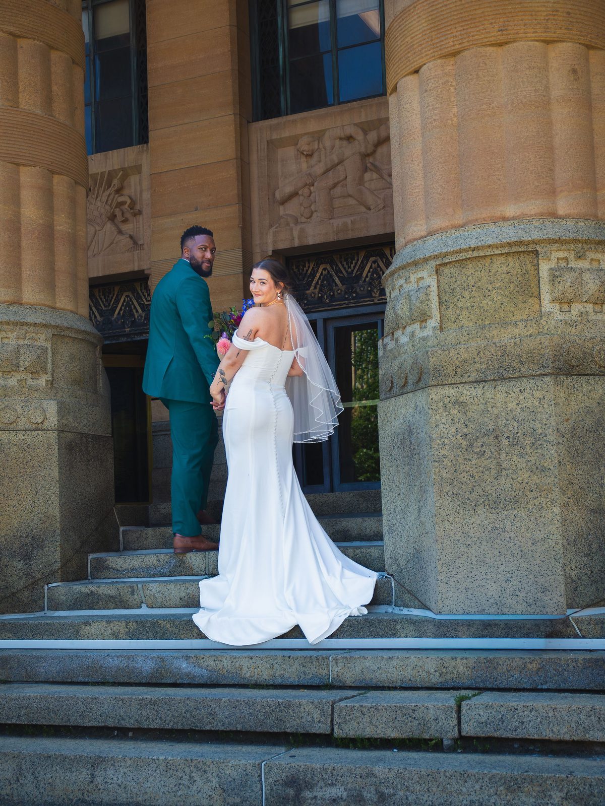 Bride and groom holding hands on the steps of The Foundry Suites